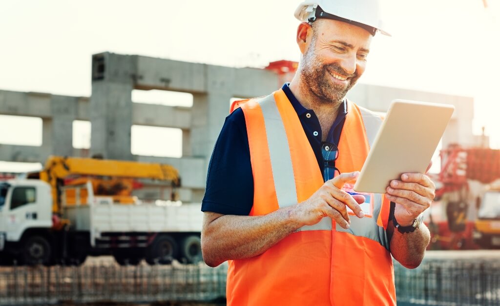 construction worker looking at a clipboard and smiling